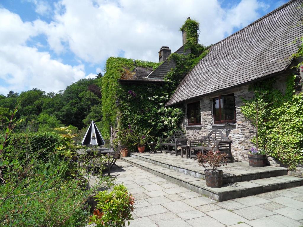 Una casa de piedra con hiedra a un lado. en Tarr Farm Inn, en  Liscombe