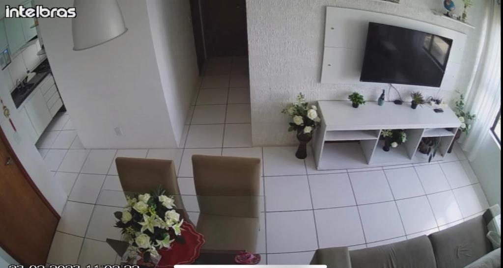 uma sala de estar com uma televisão e uma mesa e cadeiras em Carla Vaz no Recife