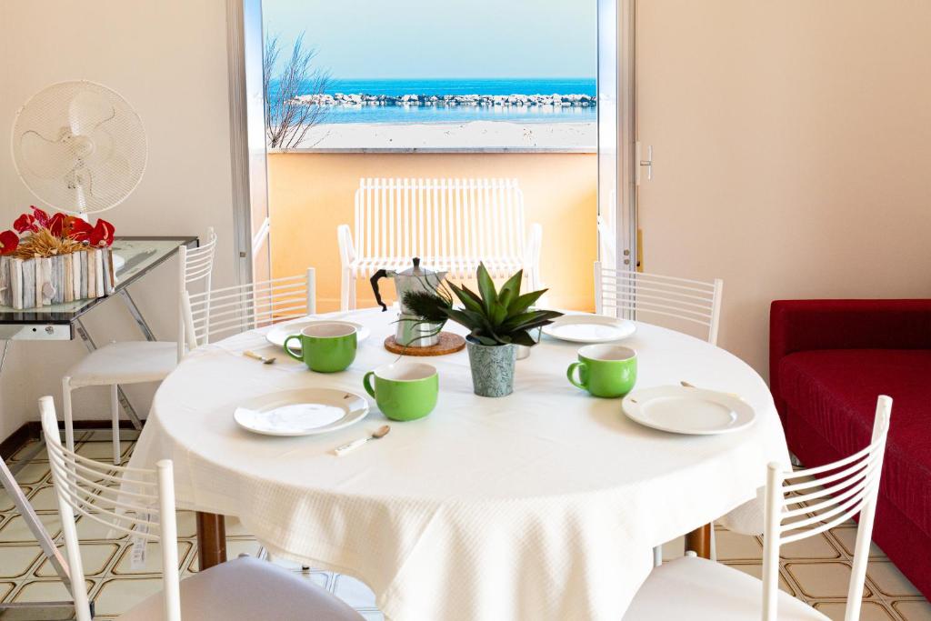 a white table with white chairs and a window at Residence Rainbow in Bellaria-Igea Marina
