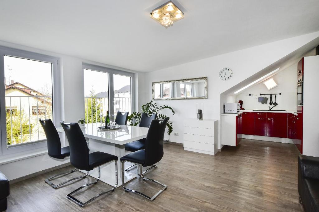 une salle à manger avec une table et des chaises ainsi qu'une cuisine dans l'établissement Domicilio Azzurro, à Lindau