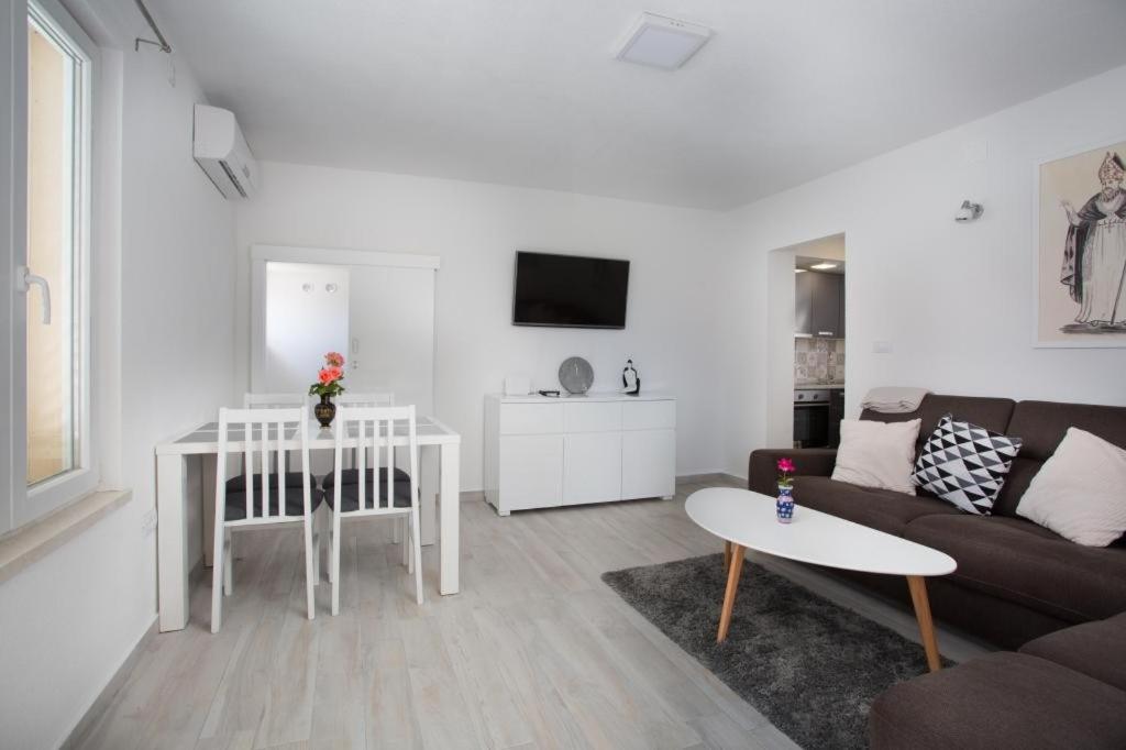 een woonkamer met een bank en een tafel bij Serious Job Apartment in Dubrovnik
