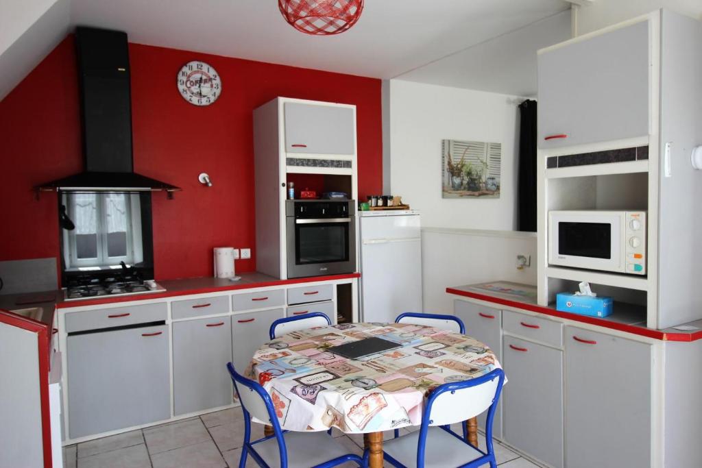 利摩日的住宿－Le coudert，厨房配有白色橱柜和桌椅