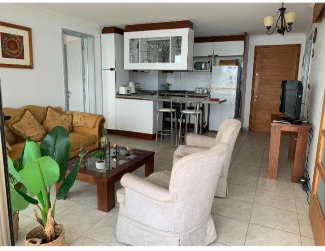 a living room with a couch and a table at Departamentos Costa Pingueral in Tomé