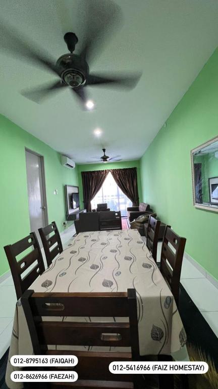 comedor con mesa grande y ventilador de techo en FAIZ HOMESTAY, en Kuching