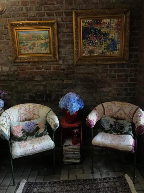 2 sillas en una habitación con una pared de ladrillo en St. Virginia’s en Gramado