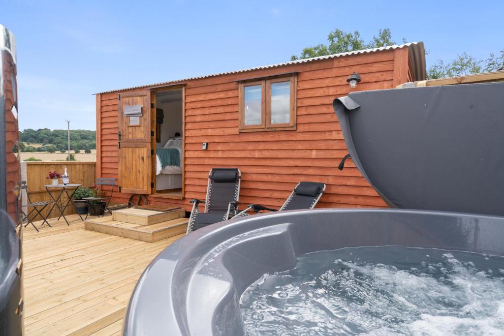 a hot tub on the deck of a tiny house at Outbak Shepherds Hut in Cheltenham