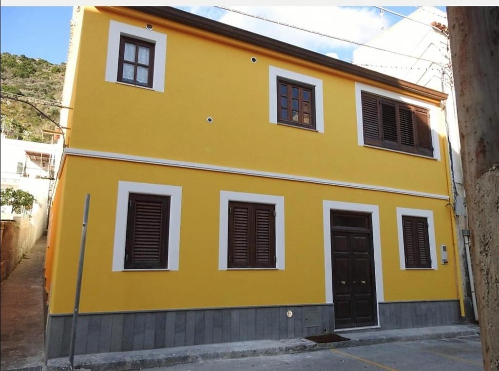 una casa amarilla con puertas y ventanas negras en Casa Assuntina, en Canneto