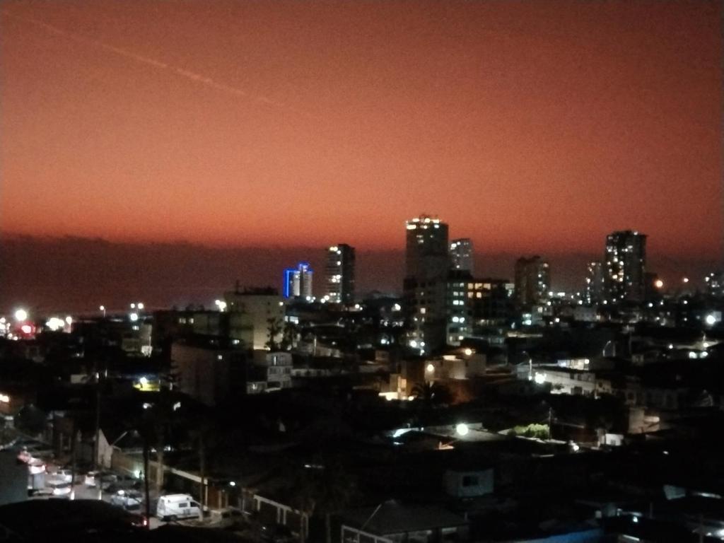 Departamento sector Cavancha في إكيكي: أفق المدينة في الليل مع الأضواء
