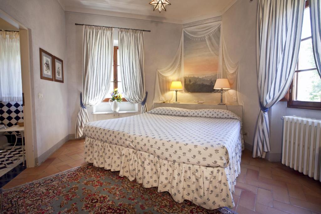 サン・カシャーノ・イン・ヴァル・ディ・ペーザにあるFonte De' Mediciの窓付きのベッドルーム1室(大型ベッド1台付)