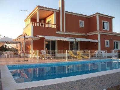 a house with a swimming pool in front of a house at Moradia Malhao in Malhão