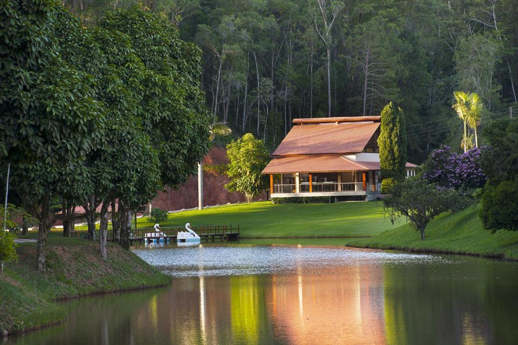 uma casa num lago com pessoas num barco em Sítio dos Lagos em Domingos Martins