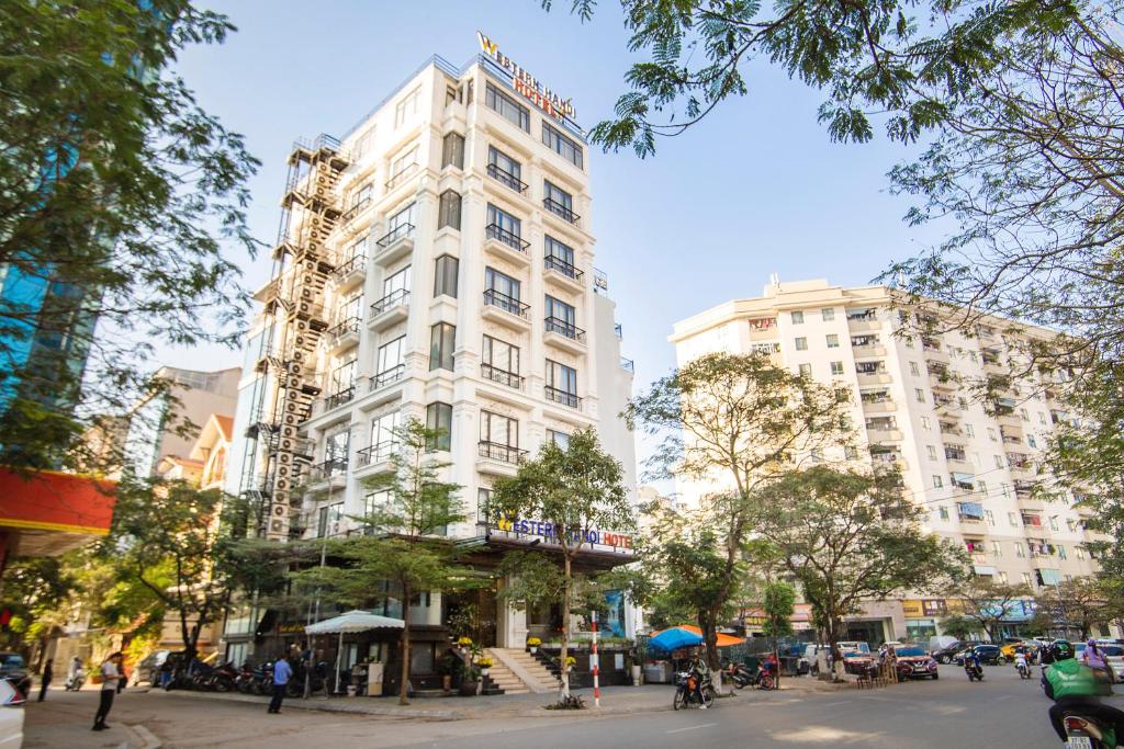 un grand bâtiment blanc dans une rue de la ville dans l'établissement Western Hanoi Boutique Hotel, à Hanoï