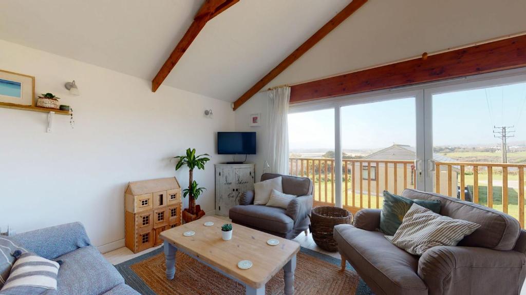 a living room with a couch and chairs and a table at E48 Redville, Riviere Towans in Hayle