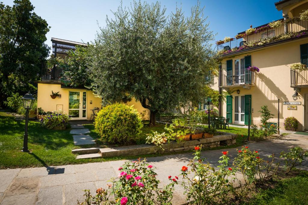een huis met een boom en bloemen in de tuin bij Residence la Limonera in Bellagio