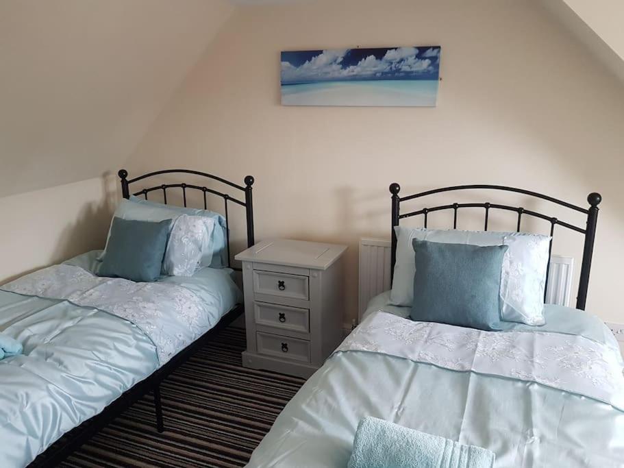 dwa łóżka siedzące obok siebie w sypialni w obiekcie No6 High Street w mieście Edwinstowe