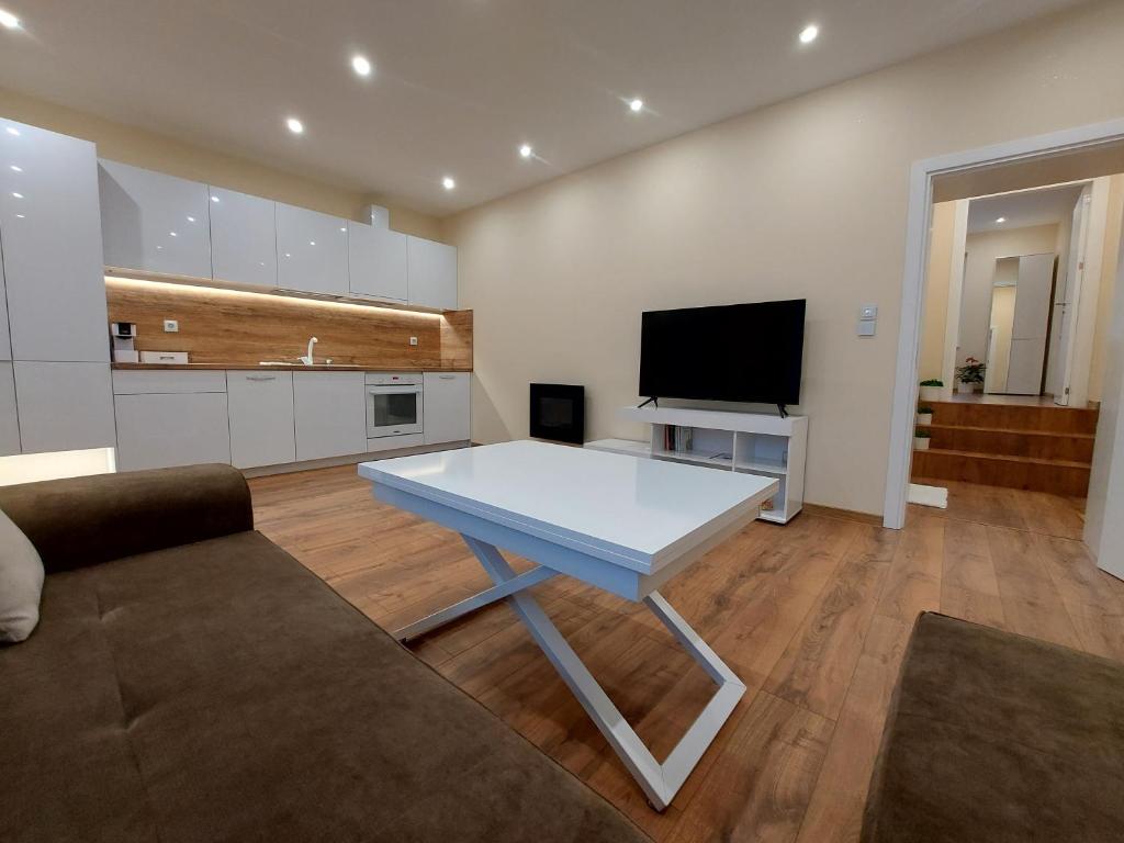 希薩里亞的住宿－Релакс Хисаря 2，客厅配有白色桌子和电视