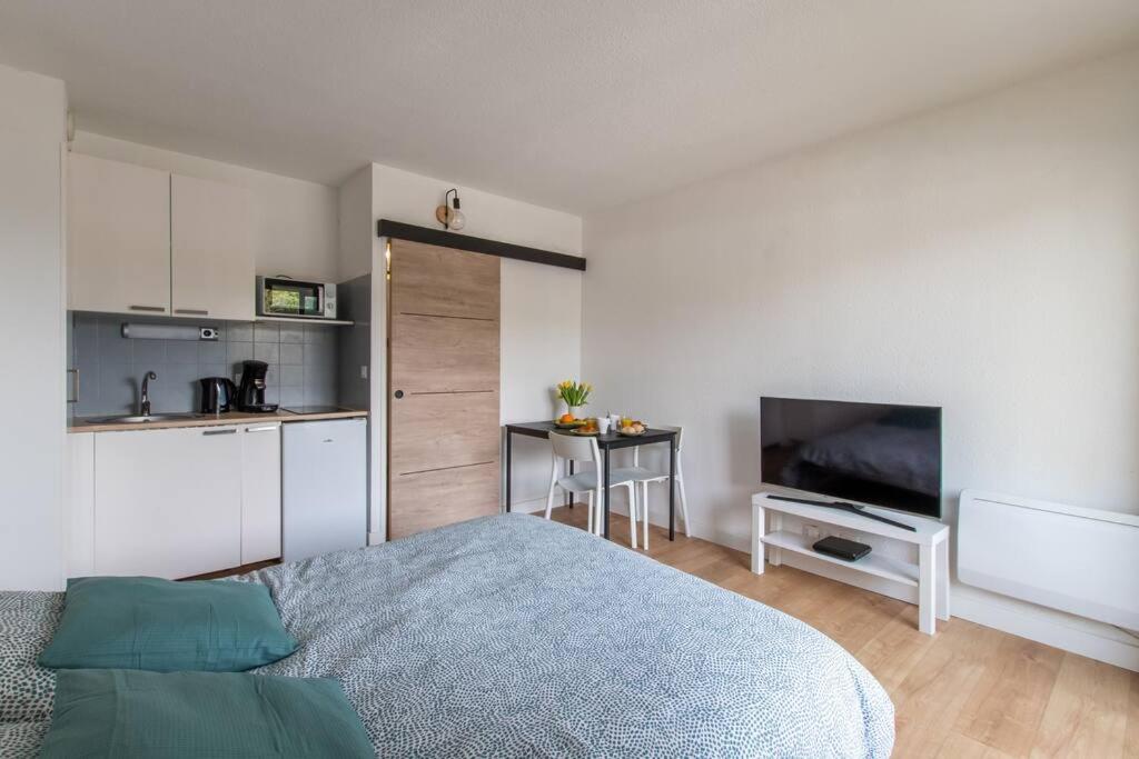 1 dormitorio con 1 cama y cocina pequeña en Escapade Ensoleillée * wifi * mer à 10 minutes, en Carnon-Plage