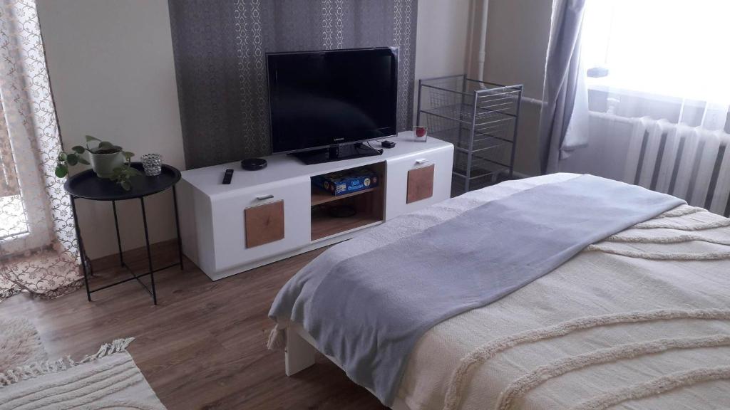 a bedroom with a flat screen tv on a white cabinet at Pilve apartment in Võru