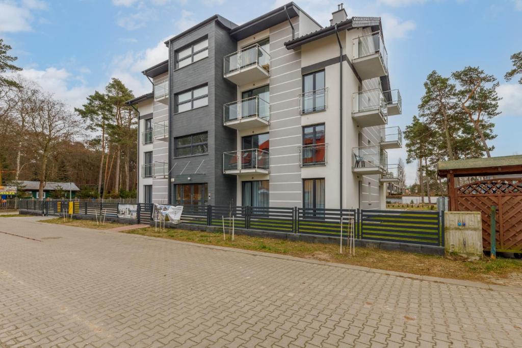 a tall white building on the side of a street at Apartment with Parking 500 m from The Sea by Renters in Międzywodzie