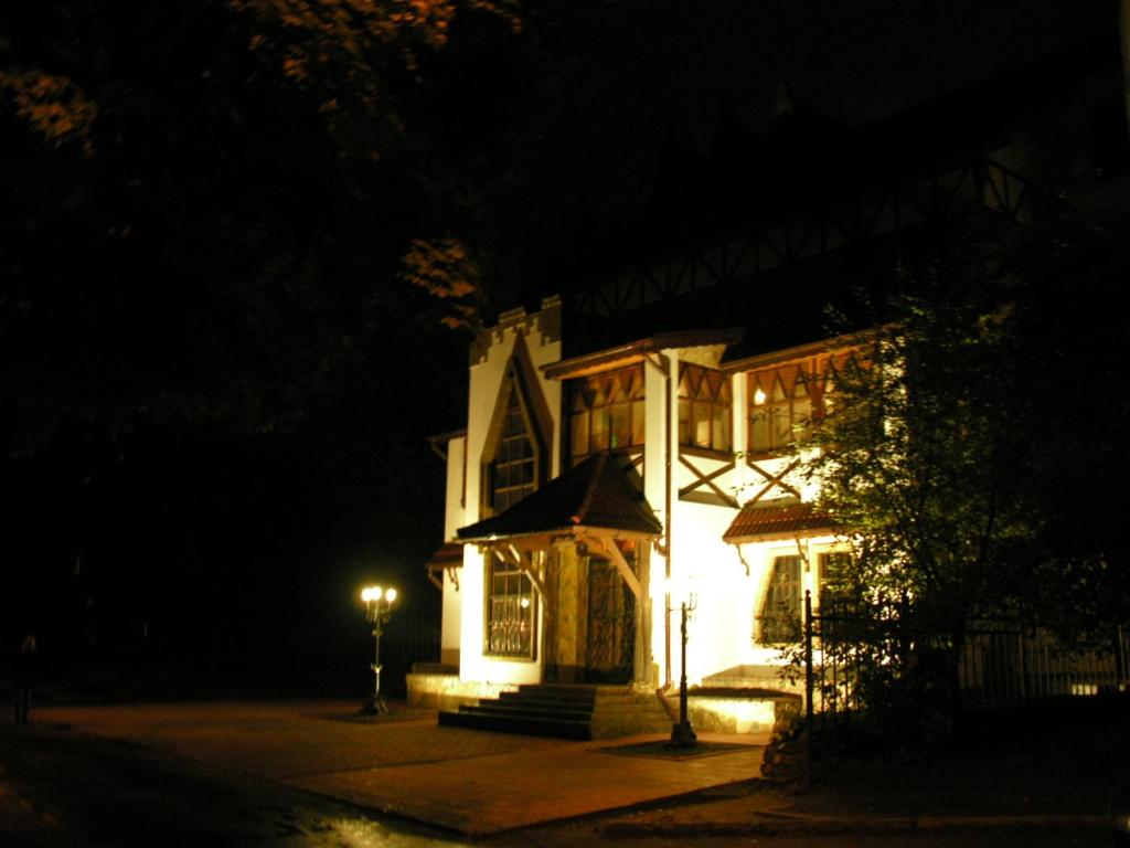 ein großes weißes Haus in der Nacht mit Lichtern in der Unterkunft Avalon in Krementschuk
