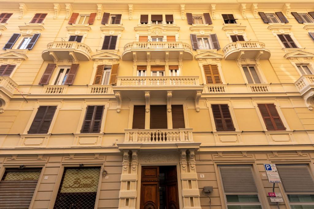 un edificio giallo con finestre e balcone di Granello Suite Central a Genova