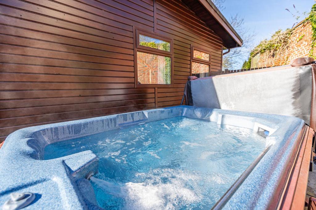 eine Whirlpool-Badewanne vor dem Haus in der Unterkunft Bluebell Lodge 7 with Hot Tub in Newton Stewart
