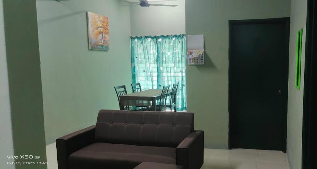 a living room with a couch and a table at Homestay Lumut in Lumut