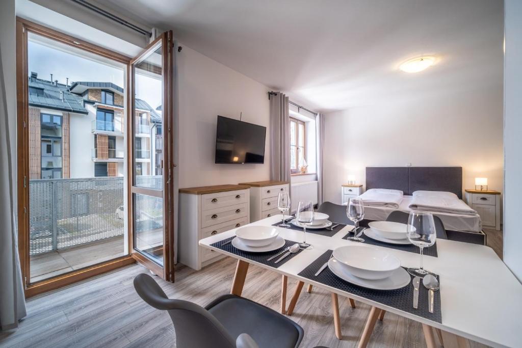 a dining room with a table and chairs and a bedroom at Apartment 123-2 Lipno Home in Lipno nad Vltavou