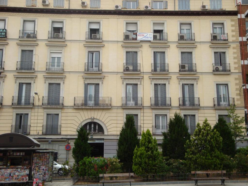 um grande edifício branco com janelas e varandas em Hostal Zamora em Madri