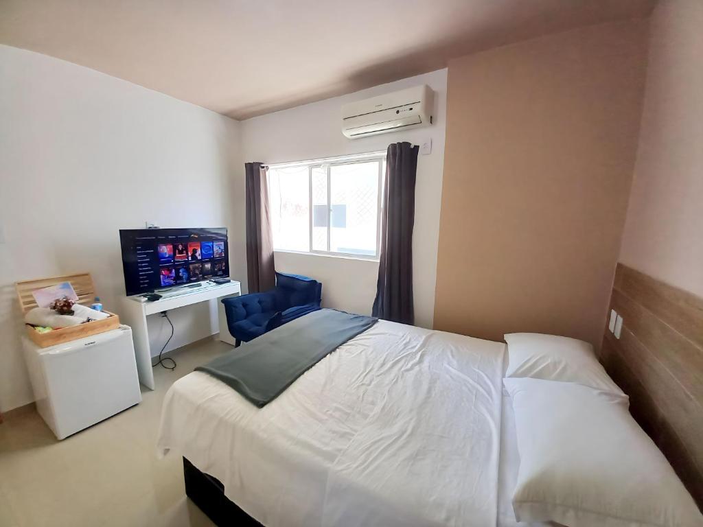 1 dormitorio con 1 cama y TV en Pé na areia, en Recife