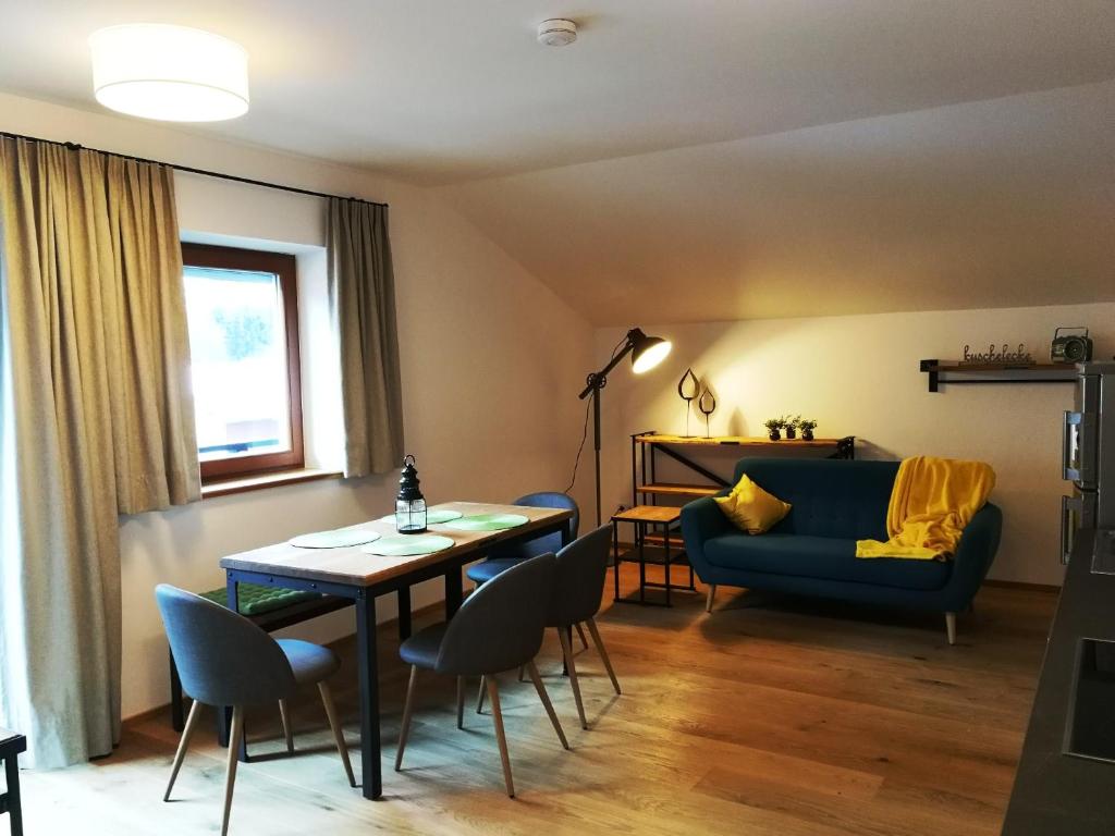 ein Wohnzimmer mit einem Tisch und einem blauen Sofa in der Unterkunft Quartier No. 7 - Serviced Living in Grödig