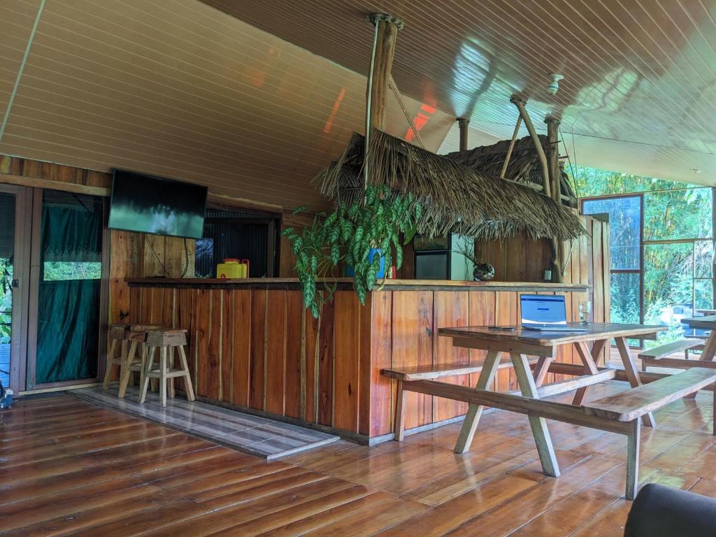 德雷克的住宿－Corcovado Mountain House，一间设有桌椅的房间和一间酒吧