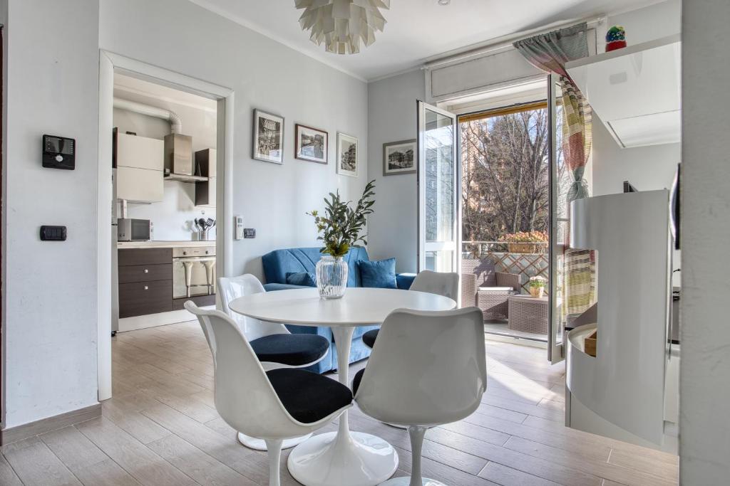 a kitchen and living room with a table and chairs at ALTIDO Delightful flat with balcony in Milan