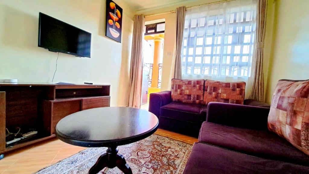 uma sala de estar com um sofá roxo e uma mesa em Pinnacle Homes em Naivasha