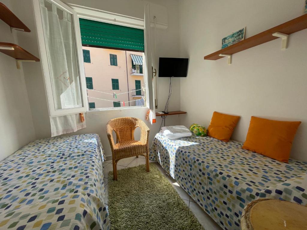 a bedroom with two beds and a window at Giuly's Room in Porto Santo Stefano
