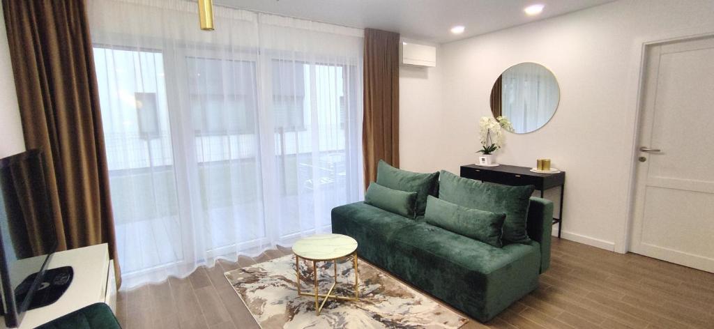a living room with a green couch and a mirror at NEW Apartment J22, Free Private Parking, Terrace, Self Check-in in Kaunas