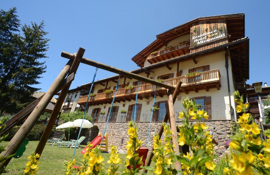 un bâtiment avec une clôture devant lui dans l'établissement Residence Miramonti, à Daiano