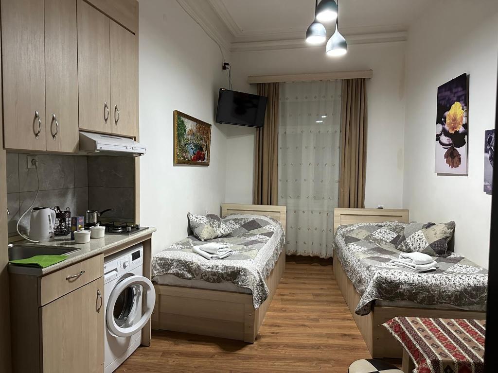 un soggiorno con 2 letti e una cucina di Leselidze Guest House a Tbilisi City