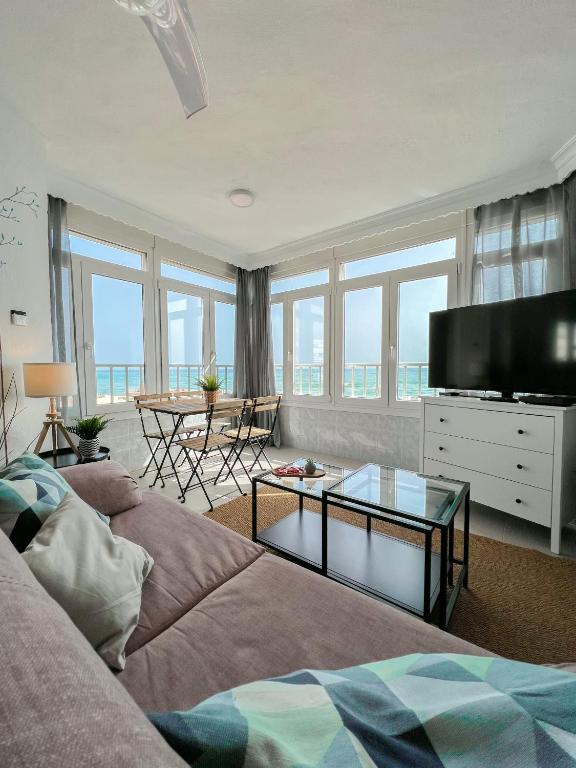 ein Wohnzimmer mit einem Sofa und einem Flachbild-TV in der Unterkunft Beautiful sea views apartment Pool & Beach in Torremolinos