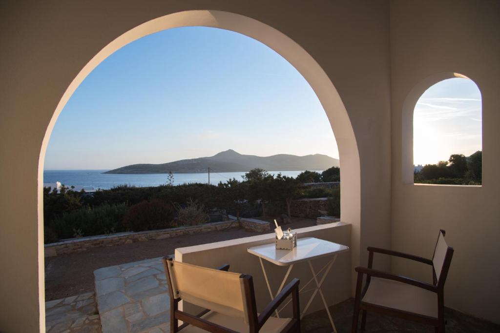 a room with a table and chairs and a view of the ocean at Oliaros seaside complex in Agios Georgios