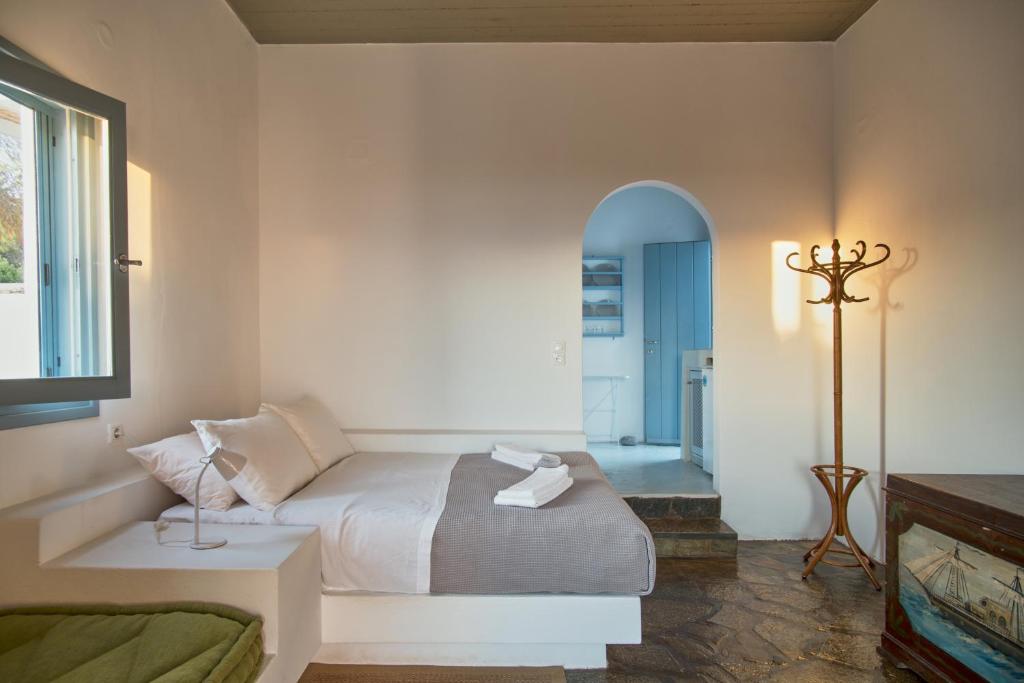 a bedroom with a bed and a room with a bathroom at Oliaros seaside complex in Agios Georgios
