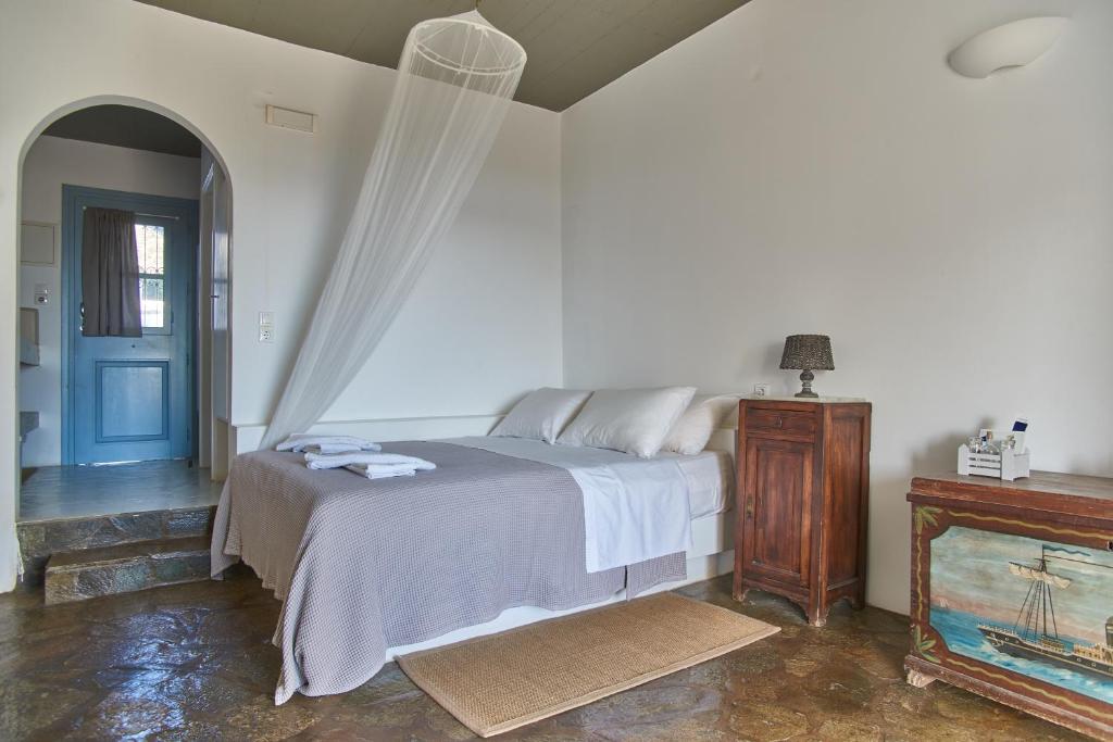 a bedroom with a bed and a blue door at Oliaros seaside complex in Agios Georgios