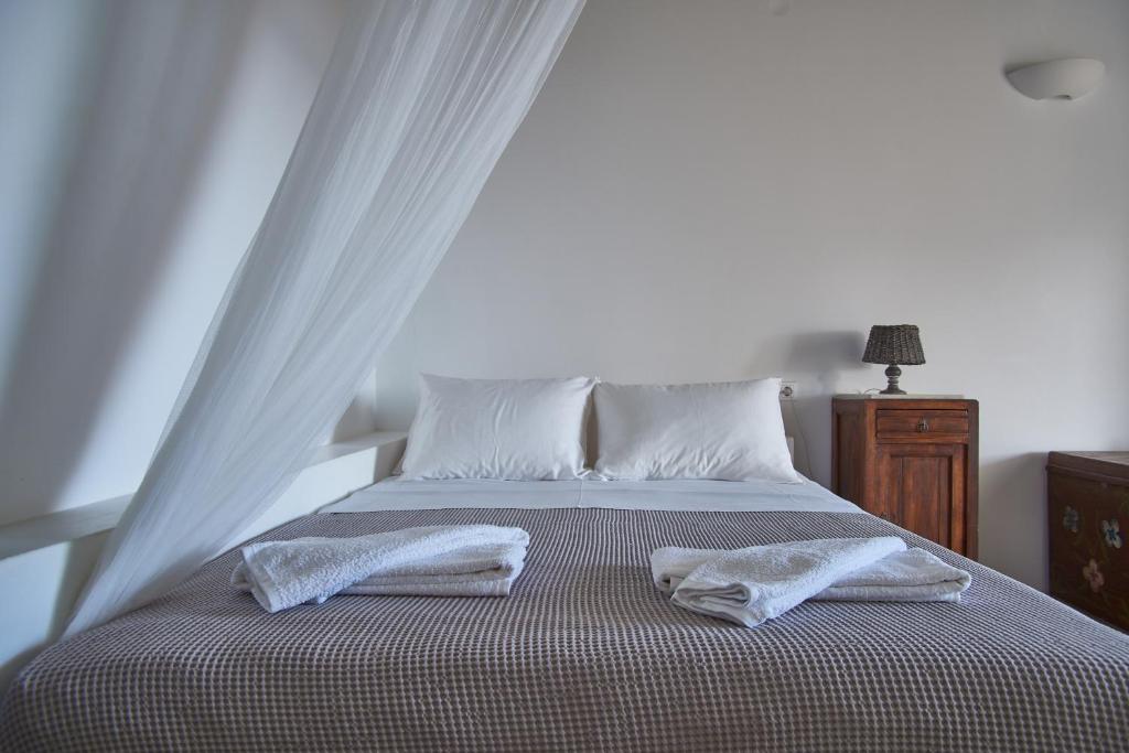 a bedroom with a bed with two towels on it at Oliaros seaside complex in Agios Georgios
