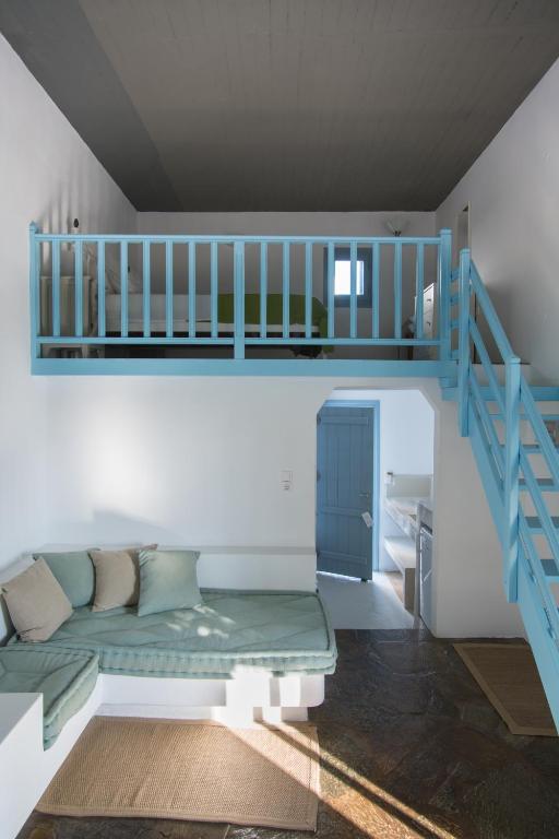 a living room with a couch and a staircase at Oliaros seaside complex in Agios Georgios