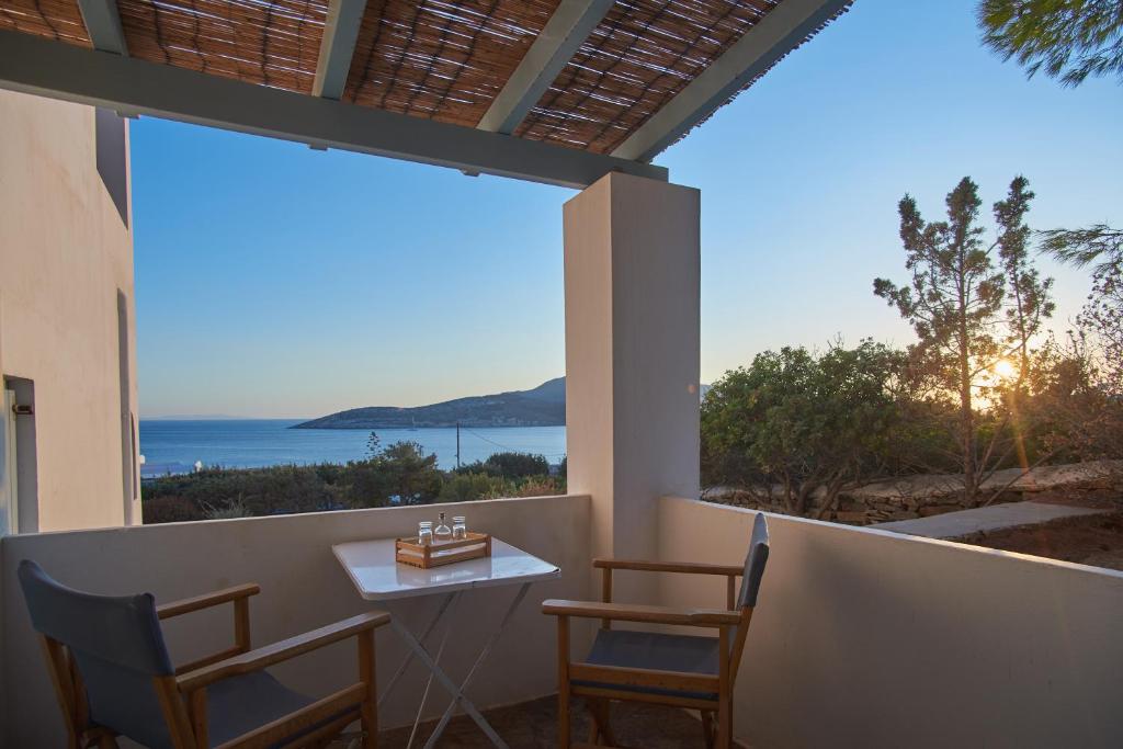 a balcony with a table and chairs and a view of the ocean at Oliaros seaside complex in Agios Georgios