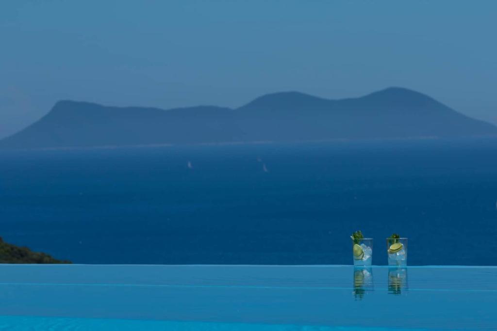 two bottles sitting in the water in the ocean at Villa Eione in Sivota