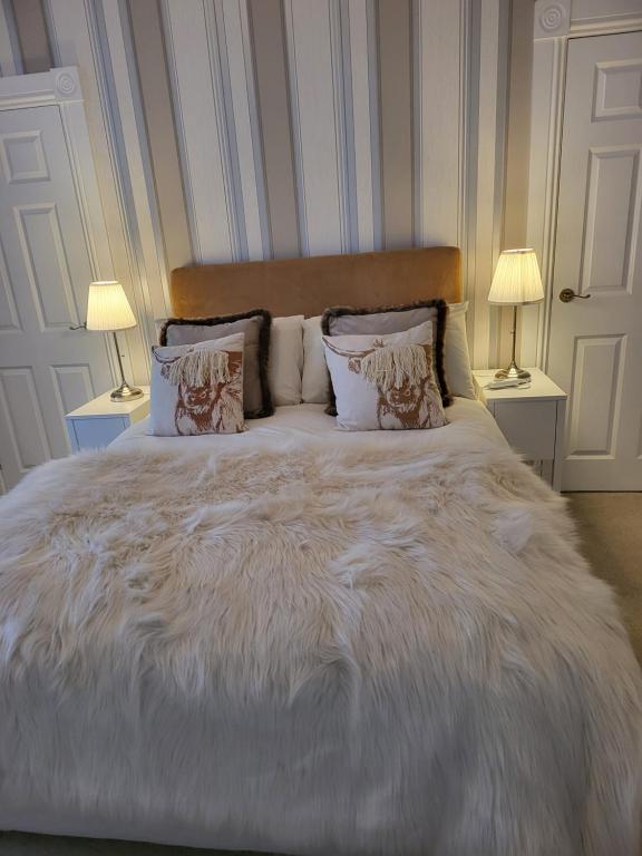 1 cama blanca grande con 2 lámparas en 2 mesas en Langhouse Castle Bed and Breakfast, en Inverkip