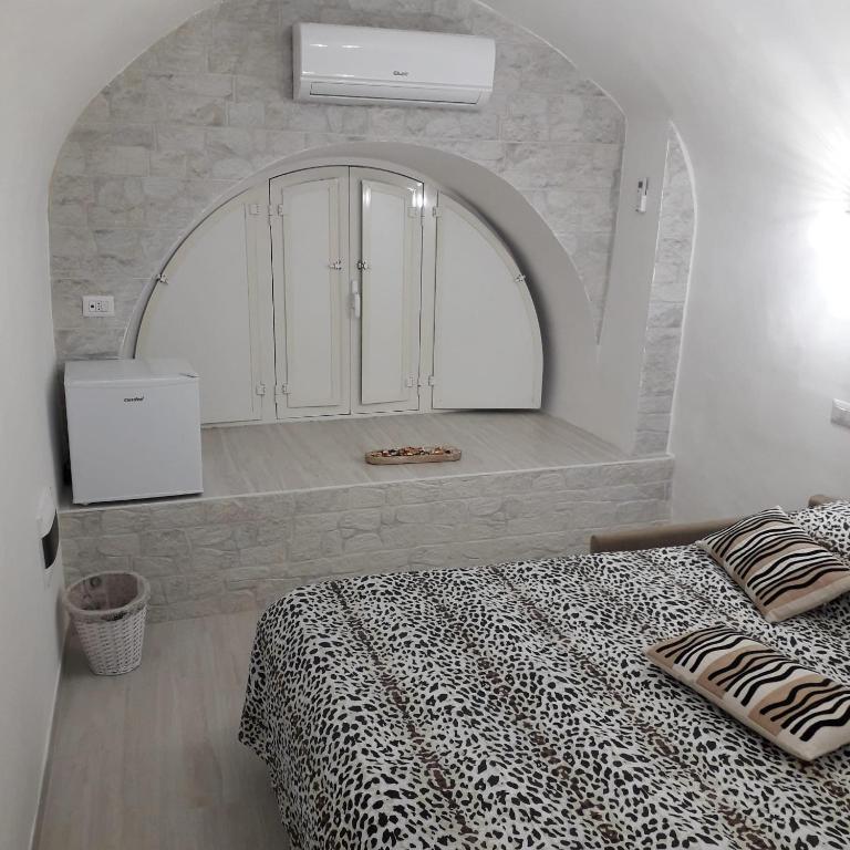 um quarto com uma cama com uma parede de pedra em La petite Maison Bari em Bari
