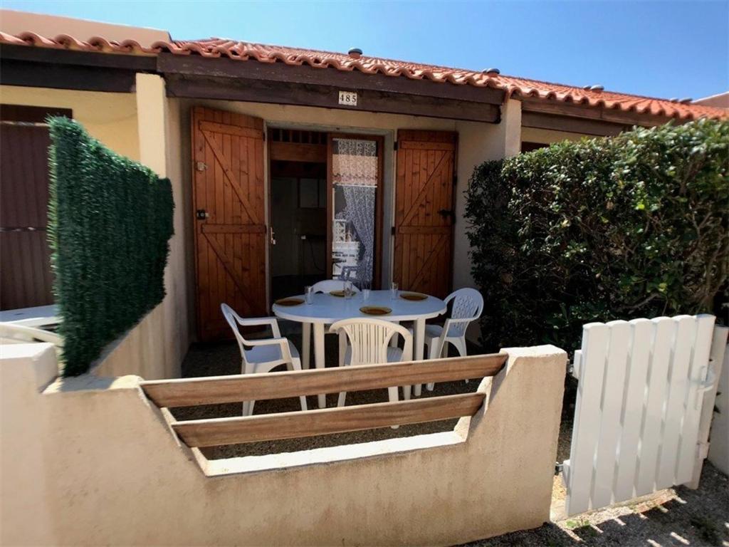 une terrasse avec une table et des chaises dans une maison dans l'établissement Charmante Villa T1+Cabine+Mezzanine – 4 pers, Terrasse, Parking, Proximité Commerces, Bord de Lac - FR-1-81-53, à Port-Leucate