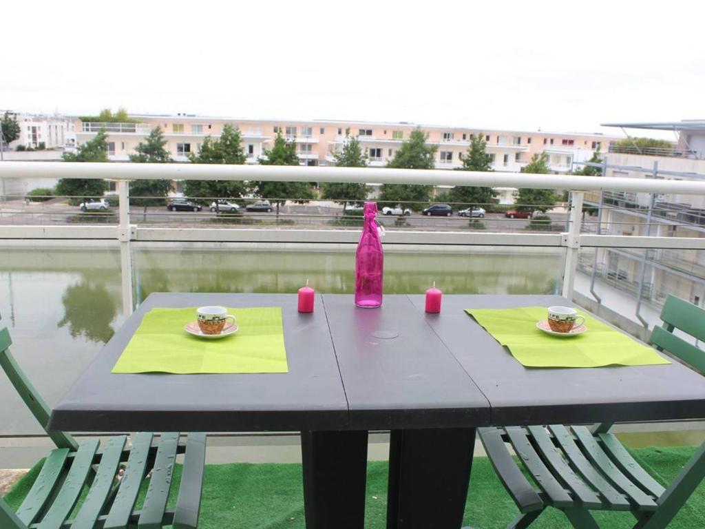 ラ・ロシェルにあるAppartement La Rochelle, 1 pièce, 2 personnes - FR-1-246-48のテーブル(椅子2脚付)、バルコニー(ピンクのボトル1本付)